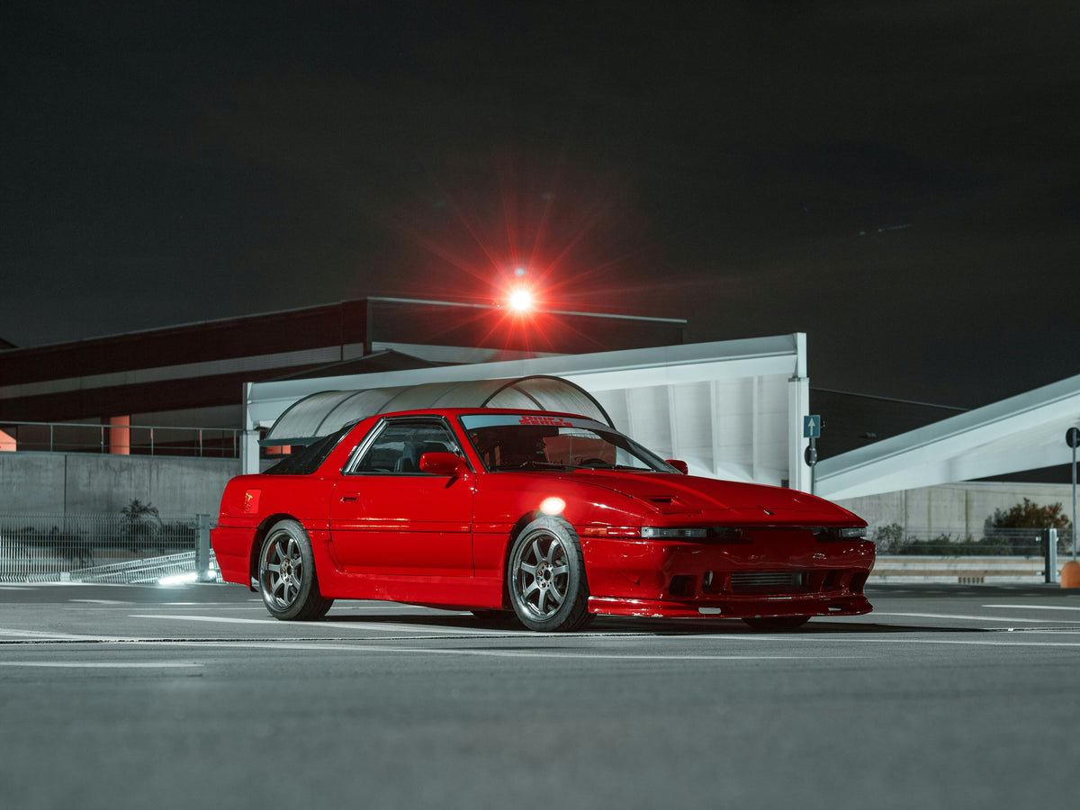 Red MK3 A70 Toyota Supra parked outdoors