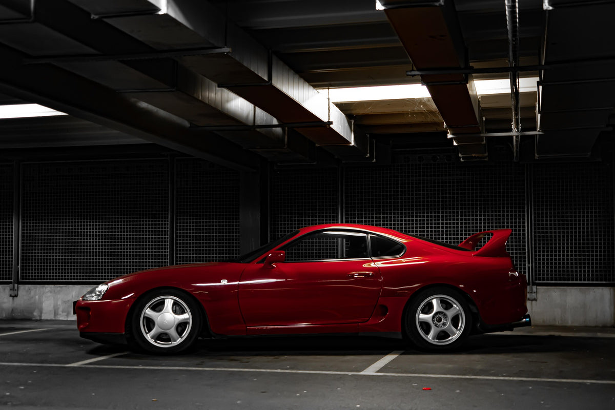 Red MK4 A80 Toyota Supra parked inside a building